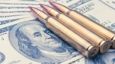 on the banknotes of dollars are fighting bullets close-up. Concept of war and money
