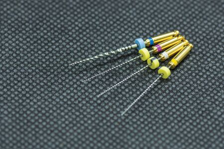 endodontic needles for the treatment of pulpitis and tooth roots close-up on black background. Tooth...