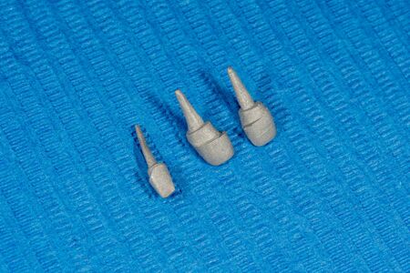 metal cast pin of a human tooth on a gypsum model close-up in dental laboratory. Orthopedic...