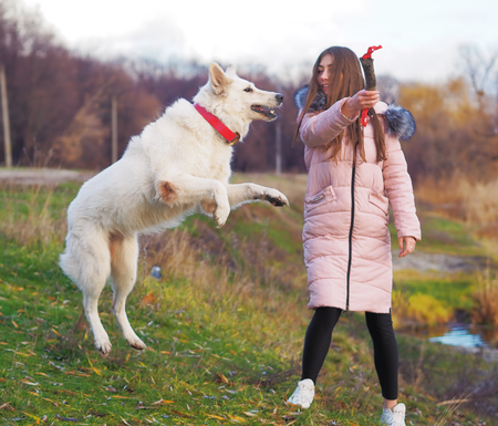 Young girl with dog running at the forest