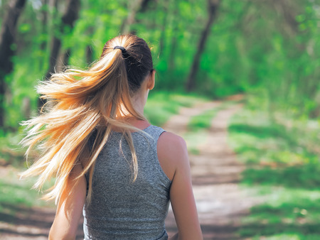 Young girl running at the forest happy