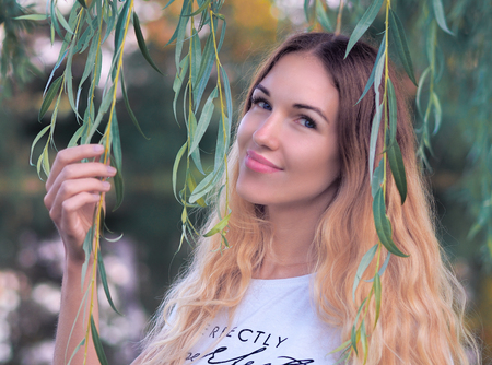 Young model near the tree with green leaves