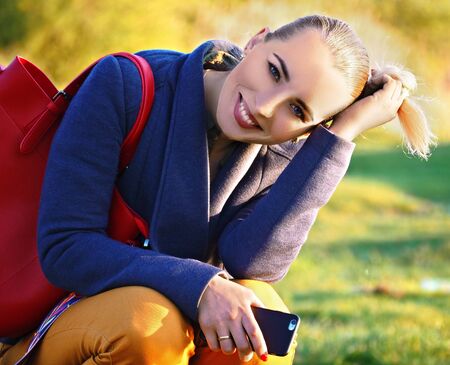 Girl young and beautiful sitting smiling and looking at cameraの写真素材