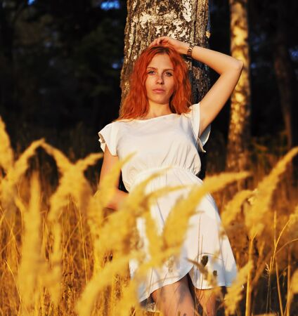 Girl redhead portrait at the yellow spikeletsの写真素材