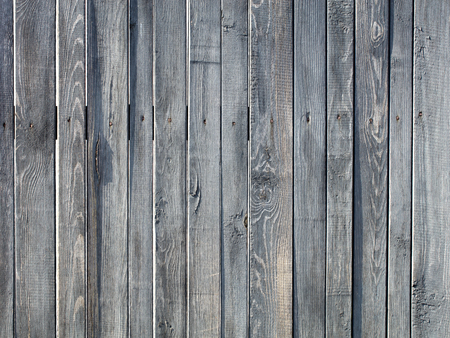 Weathered old gray wooden fence nailed with rusty nailsの写真素材