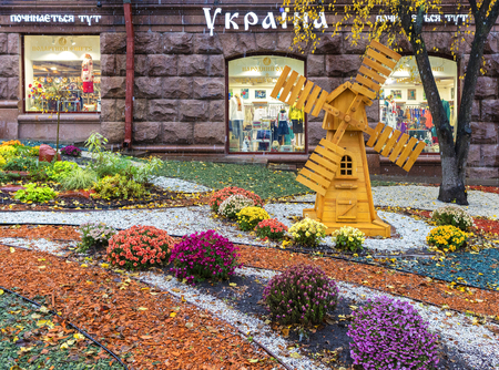 Kiev, Ukraine - October 2017: a flowerbed and wooden mill in front of the entrance to the store Ukraine in the center of Kievのeditorial素材