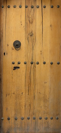 wooden door with wrought iron elements close up.の写真素材