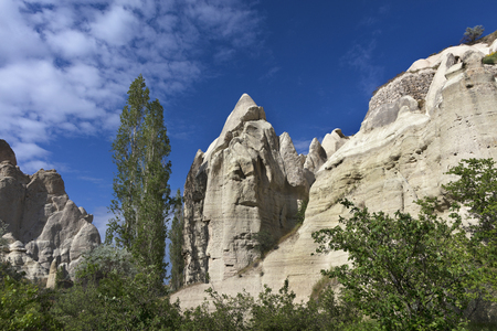 Red and white sandstone cliffs, ancient caves in a mountain landscape between valleys in Cappadocia, central Turkeyの写真素材