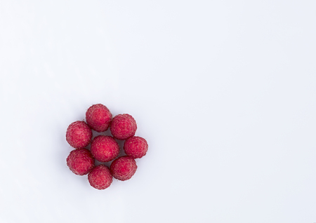 Ripe and red raspberries are arranged in a circle on a light background, a picture in a high keyの写真素材