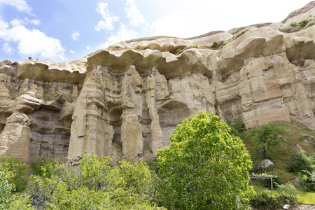 Red and white sandstone cliffs, ancient caves in a mountain landscape between valleys in Cappadocia, central Turkeyの写真素材
