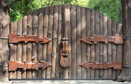 The old and mysterious wooden gate is closed to a large wooden castle - this is the entrance to the magic forestの写真素材