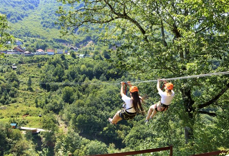 Girls on the cable car are sent through the mountain and the forest through the valley of the river...