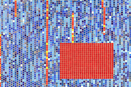 A bright abstraction of a mosaic wall of ceramic blue mosaic in the middle of a rectangle of red mosaic.の写真素材