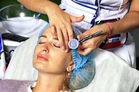 The master cosmetologist makes mesotherapy of the skin and facelift for the skin of the face of a young girl.の写真素材
