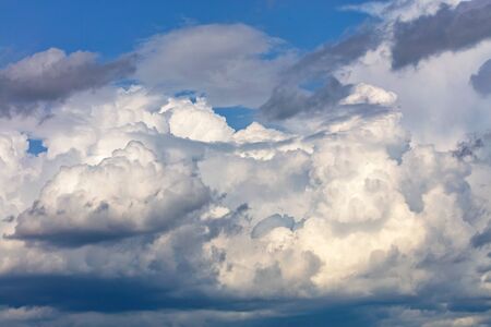 White-gray cumulus clouds gradually gather together into one continuous cover in anticipation of rain.の写真素材