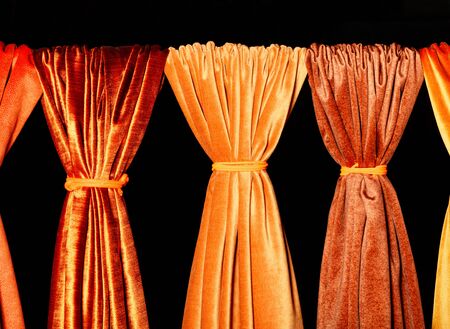 Bright and colorful palette of natural fabrics of gold, orange and yellow shades on a black background. Technology, style and beauty concept in the interior.の写真素材