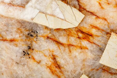 Brown cracks in the heterogeneous structure and surface texture of beige marble, close-up, top view.の写真素材