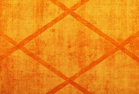 The texture of the textile cotton fabric and the surface is bright orange with a symmetrical rhombic pattern.の写真素材