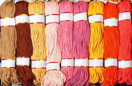 Skeins of polyester cord in various bright colors of hot shades, rolled into rolls, close-up, copy...