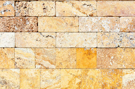 Wall background and texture of hewn yellow seashell stone, close-up.の写真素材