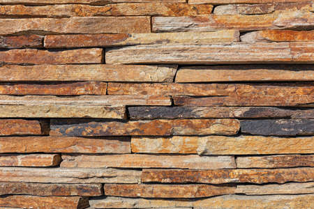 Wall background and texture of brown old slate stone, close-up.の写真素材