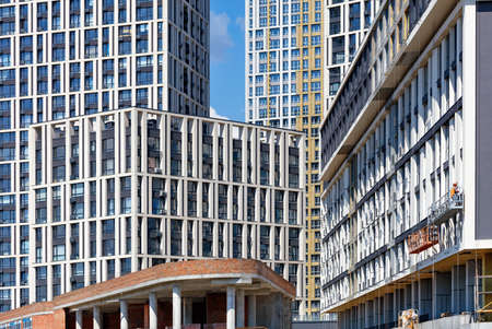 Active construction and facades of new apartment buildings in a residential area of the city block...