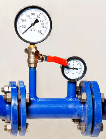 Water metering and pressure system installation, close-up of pressure gauges, pipes and taps, copy space, vertical image.の写真素材
