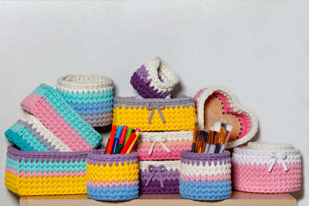Multi-colored wicker textile baskets of rectangular and round shape for storing women's cosmetics and jewelry, close-up, copy space.の写真素材