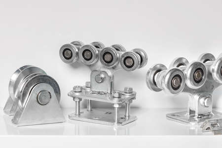 Steel special roller bearing mechanisms with a strong metal platform for moving heavy loads. Light background, close-up, copy space.の写真素材