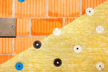 The concept of reducing heat loss in modern buildings, insulation of a brick wall of a building with mineral wool.の写真素材