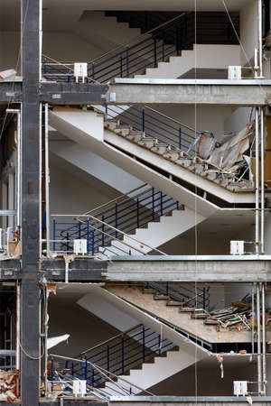 Concrete staircase between the floors of the building against the background of the destroyed facade of the house.の写真素材