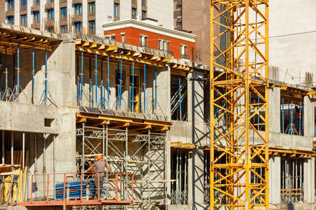 A fragment of the construction of a new building in a monolithic-frame method with a formwork system for the supporting structures of the house against the background of a workplace.の写真素材