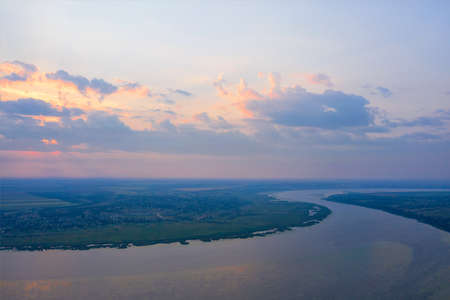 Beautiful sky over the Southern Bug river on a summer morning in the rays of the rising sun. Aerial photography, copy space.の写真素材