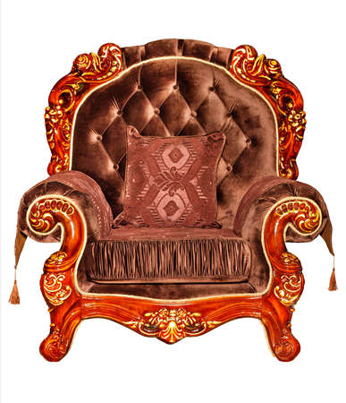 A beautiful soft armchair upholstered in expensive brown velor, with soft cushions, with a curved mahogany carved frame, photographed from the front, isolated on a white background.の写真素材