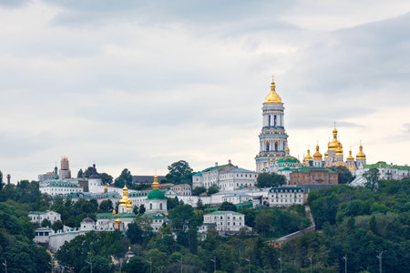 The golden domes of the Monastery of the Pechersk Lavra in Kyiv is an ancient religious complex of Christianity in Eastern Europe on the slopes of the Kiev hills on a cloudy summer day.の写真素材