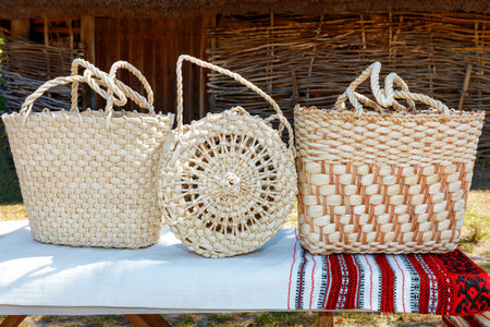Handicrafts of woven handbags in the Ukrainian traditional style on a linen embroidered towel on a...