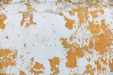 Brown old plaster on the wall with peeling whitewash and cracks. copyspace.の写真素材