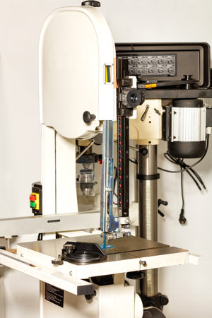 Industrial band saw with powerful motor and metal base for precise material processing. close-up....
