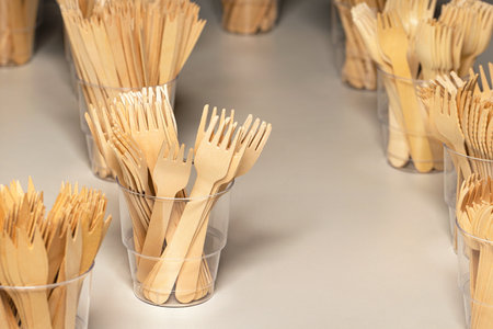 Eco-friendly disposable kitchen utensils. Wooden forks in a plastic cup. Ecology, zero waste concept.の写真素材