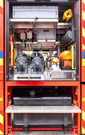 Close-up view of organized firefighting equipment within fire engine storage compartments,...