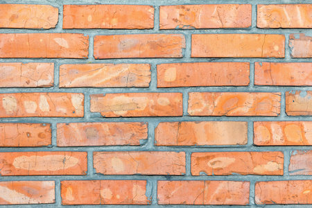 A stunning display of rustic orange bricks forms a unique wall, showcasing variations in texture and color.の写真素材