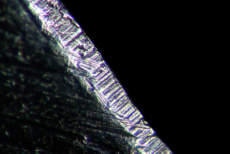 Razor blade by microscope. Microscopic scratched steel surface. Microscopically serrated bladeの写真素材