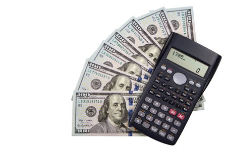 American dollars and electronic calculator, isolated on white background. On the calculator's screen, 1785 is the year when the dollar became the official currency of the U S.の写真素材