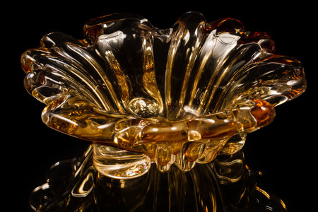 Vase of orange glass on a black background. At the bottom of the image is a reflection of the vase.の写真素材