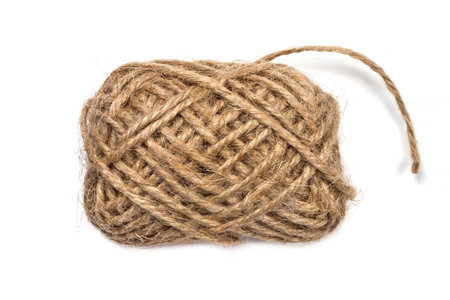 A coil of twine close-up on a white background. A ball of rope of brown color.の写真素材