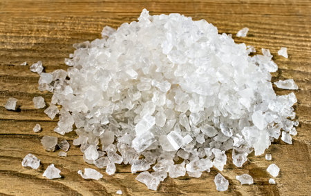 Crystals of rock salt close-up. Salt on the background of wood.の写真素材