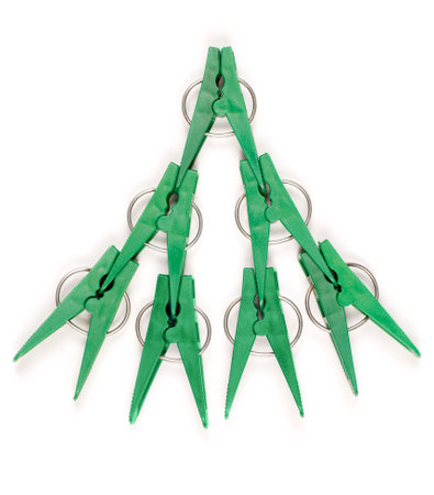Composition of green plastic clothespins in the form of spruce. Clothespins on a white background.の写真素材