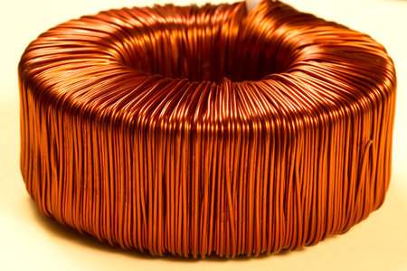 Copper wire in bright saturated color. Toroidal transformer with copper wire winding.の写真素材