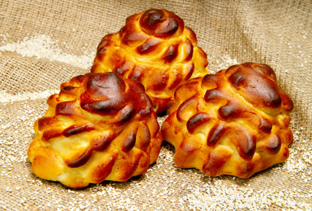 Bakery products close-up. Sweet buns with sesame seeds on a burlap background.