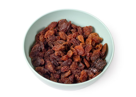 Raisins in a plate on a white background. Sweet natural raisins close-up.の写真素材